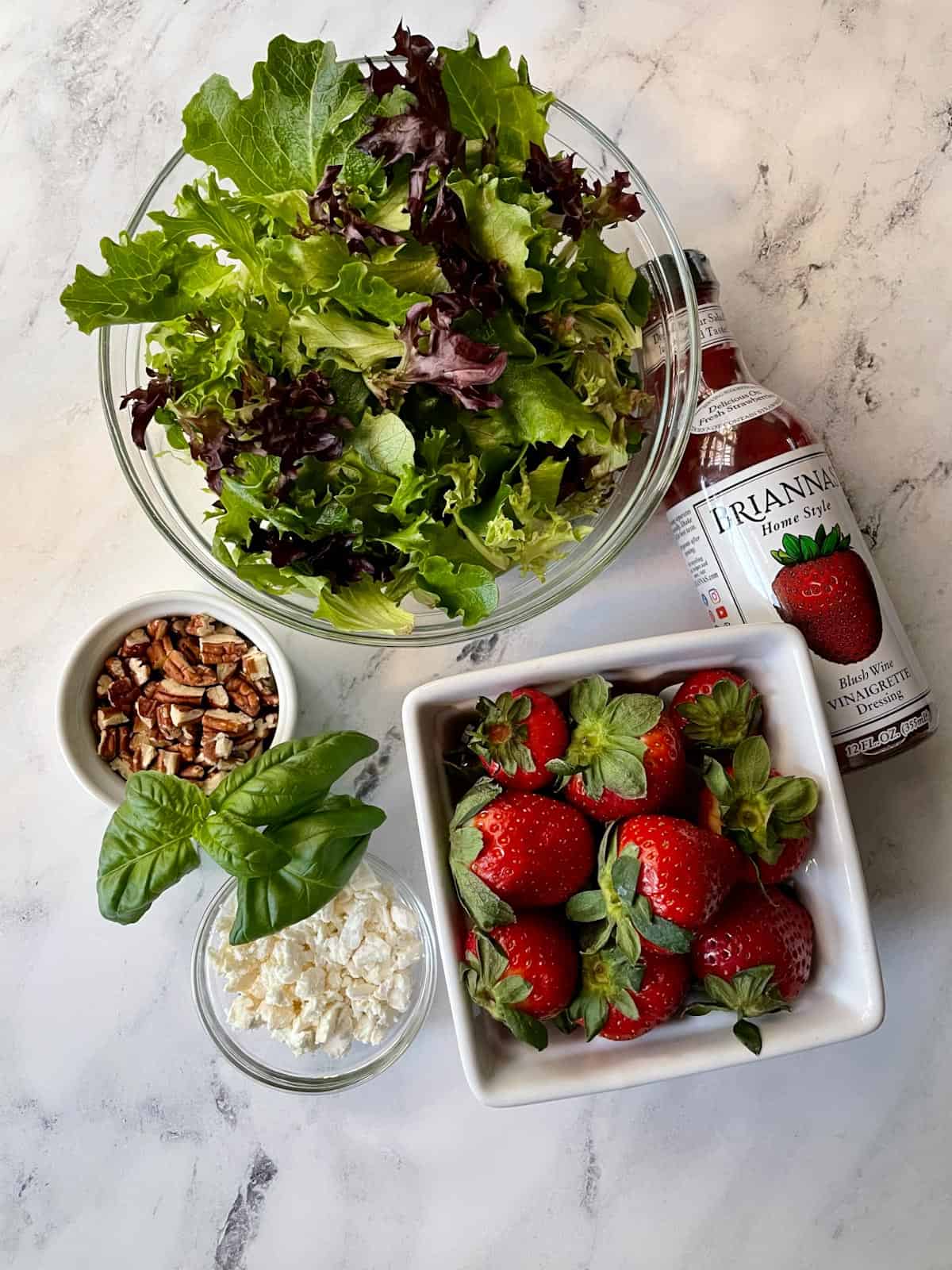 Ingredients needed for strawberry salad with feta and pecans.