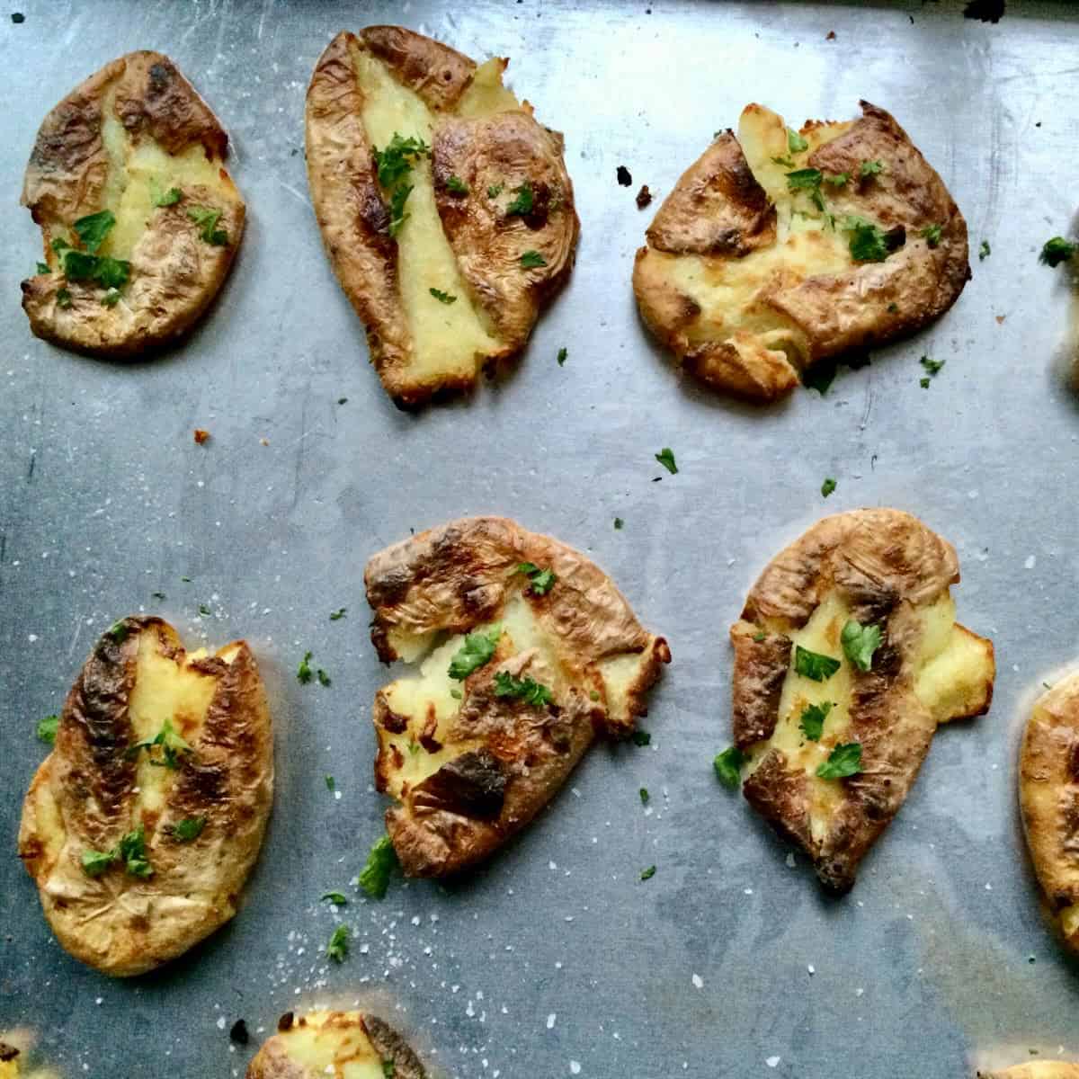 Smashed potatoes on a baking tray.