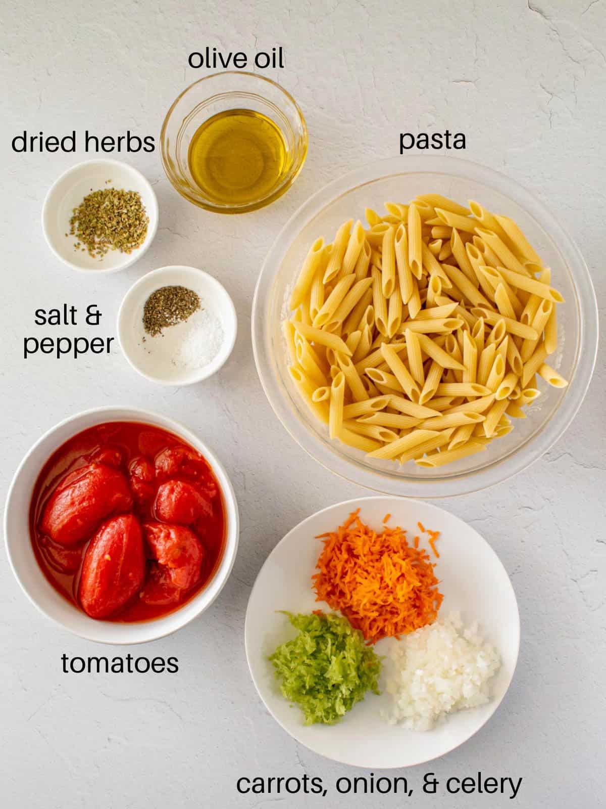 Ingredients for tomato and veggie pasta sauce ready in bowls.