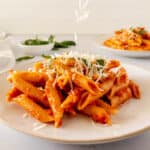 Penne pasta with tomato and veggie sauce topped with a sprinkle of cheese.