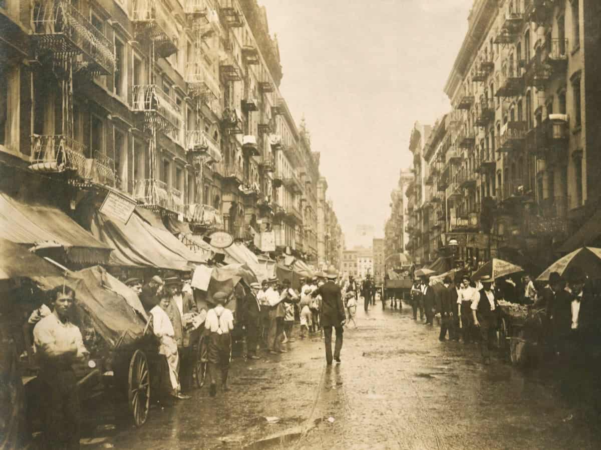 Crowded streets of Lower East Side NYC with tenements and pushcarts circa 1905.