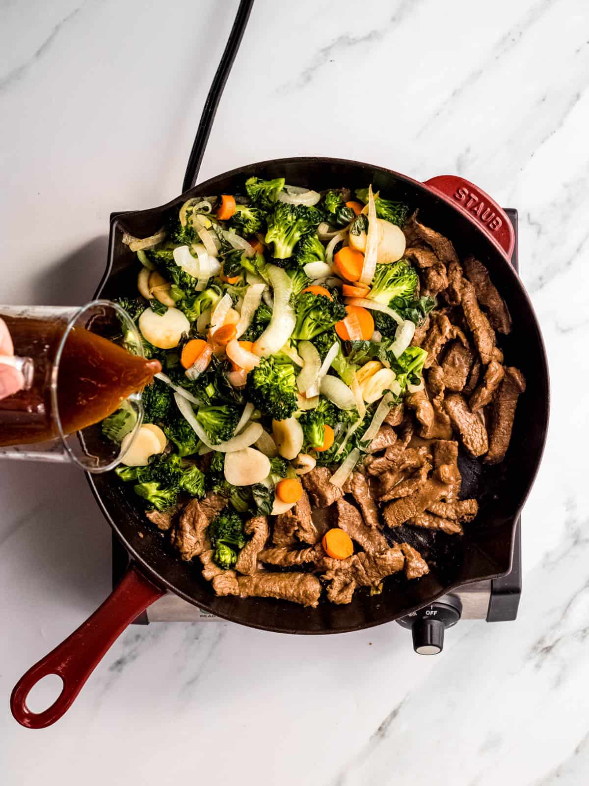 Beef and vegetables cooking in a skillet for Chinese stir fry.