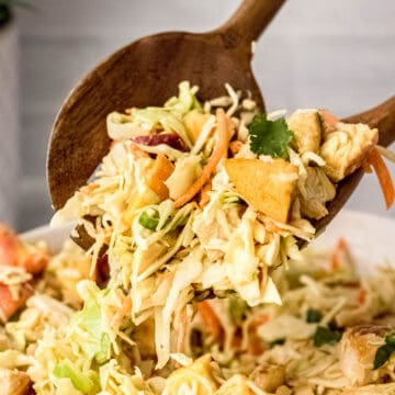 Closed up of Thai chicken salad with peanut dressing being served with wooden spoons.