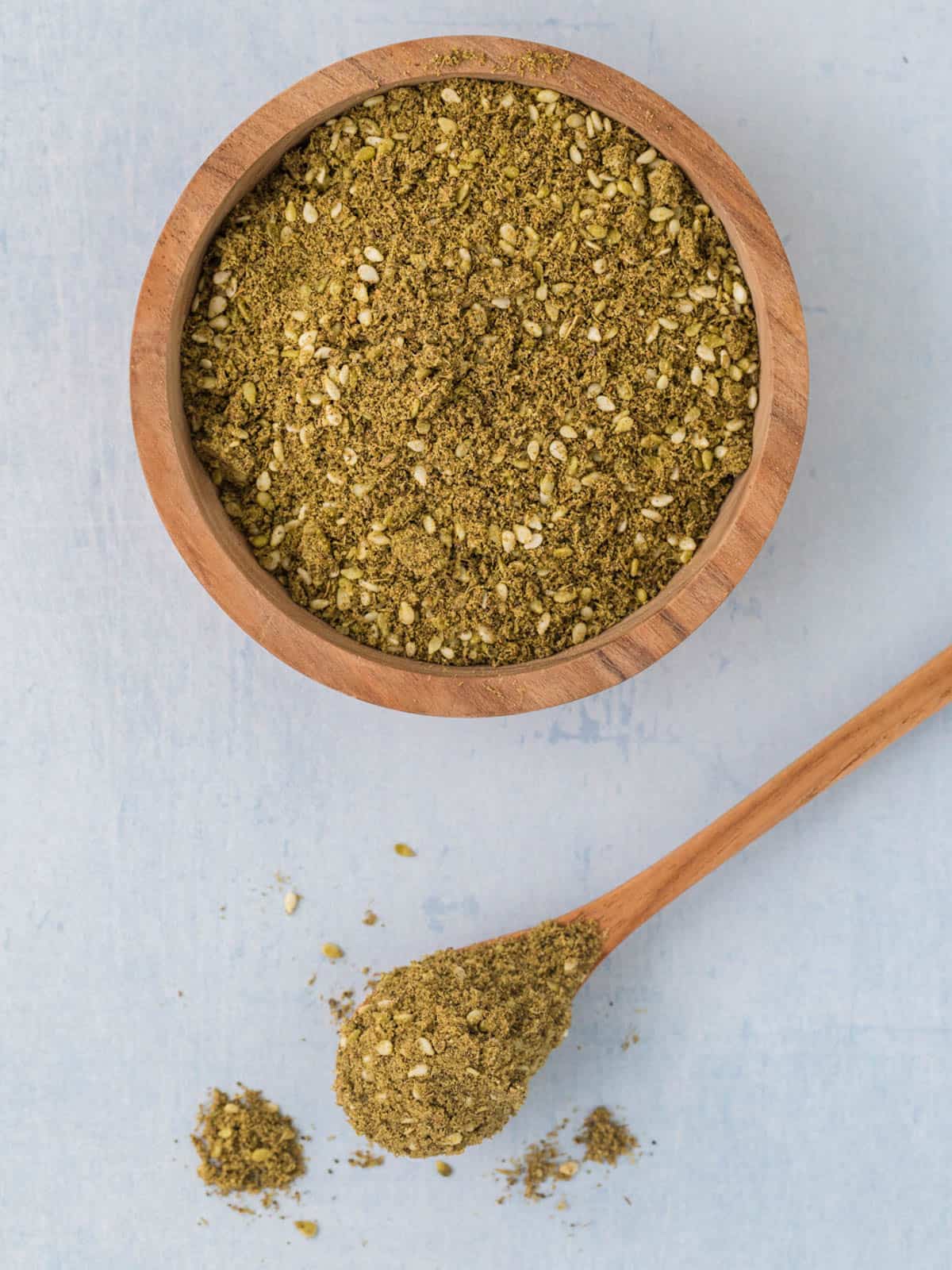Za'atar spice in a wooden bowl and on a spoon.