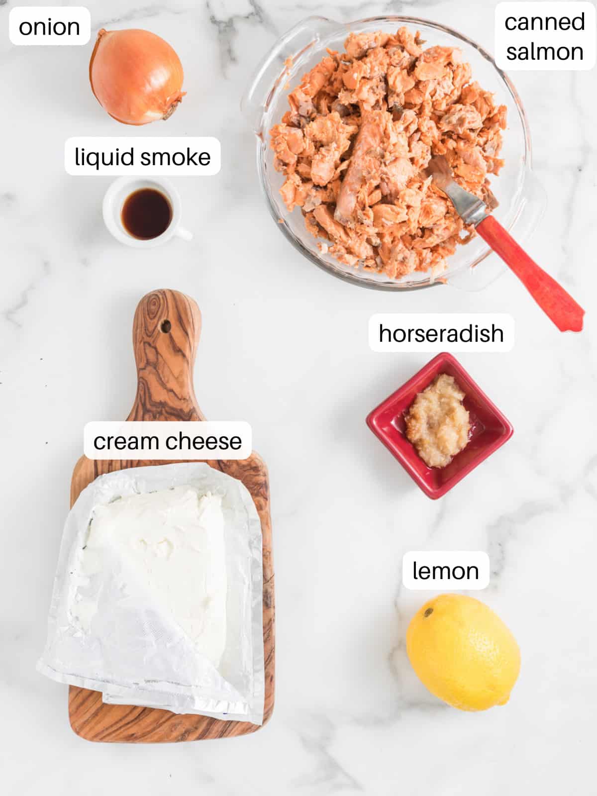 Ingredients for salmon mousse in small containers including canned salmon, cream cheese, and onion.