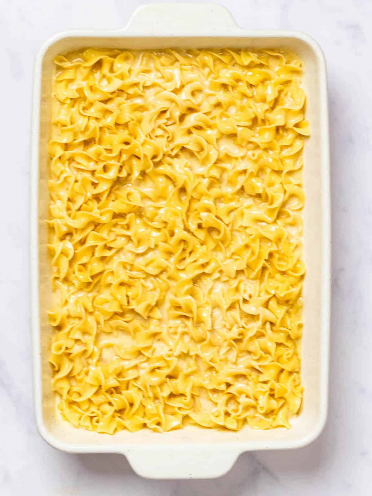 The noodles and batter are combined and in the casserole dish.