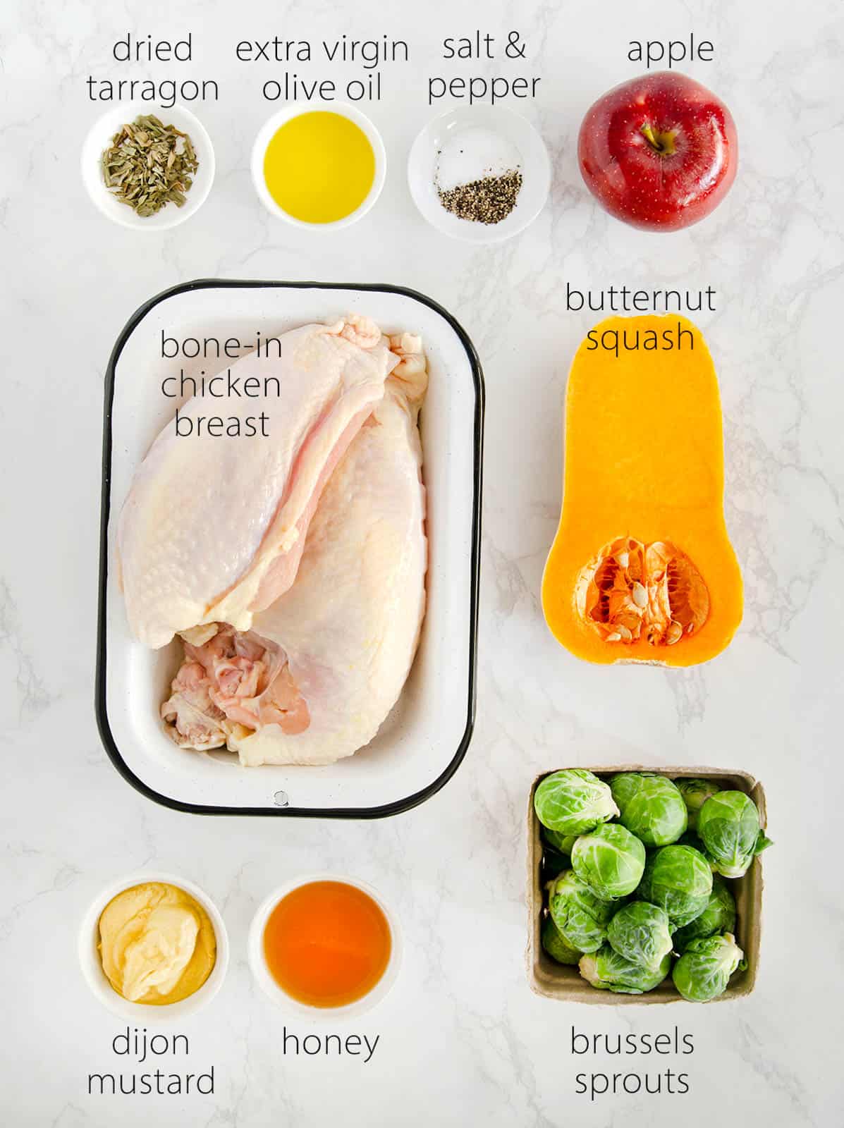 Small dishes with ingredients for honey mustard chicken including tarragon, apple, squash, and Brussels sprouts.