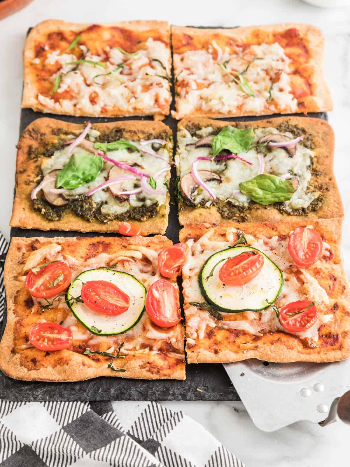 Lavash pizza with tomato sauce, cheese, and basil cooked on sheet pan.