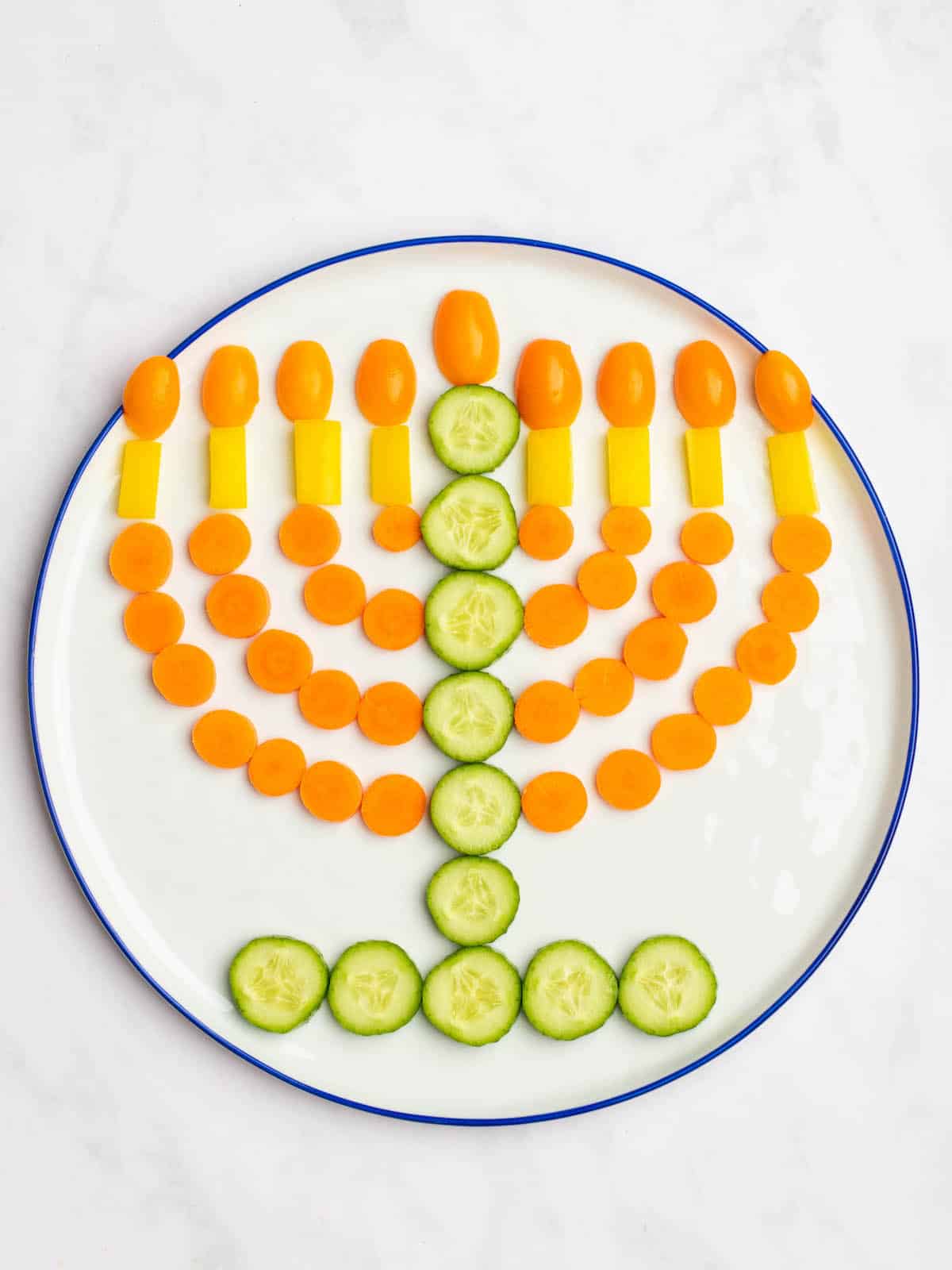 Vegetables arranged on a plate in the shape of a menorah for Hanukkah.