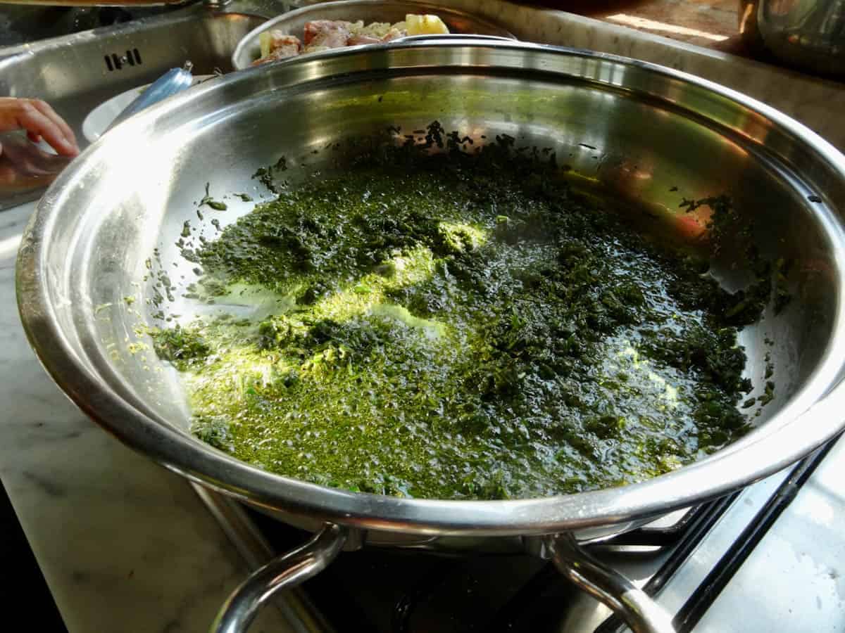 Herb, garlic, and oil mixture in a pan.