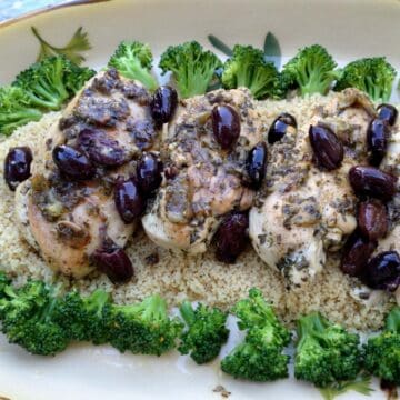 Tuscan herb chicken with lemon and olives on bed of couscous and broccoli.