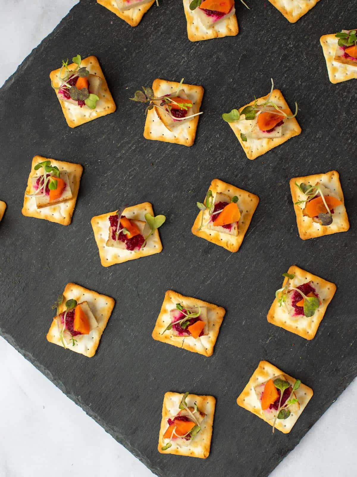 Baked gefilte fish on matzo crackers topped with beet horseradish, microgreens, and carrots.