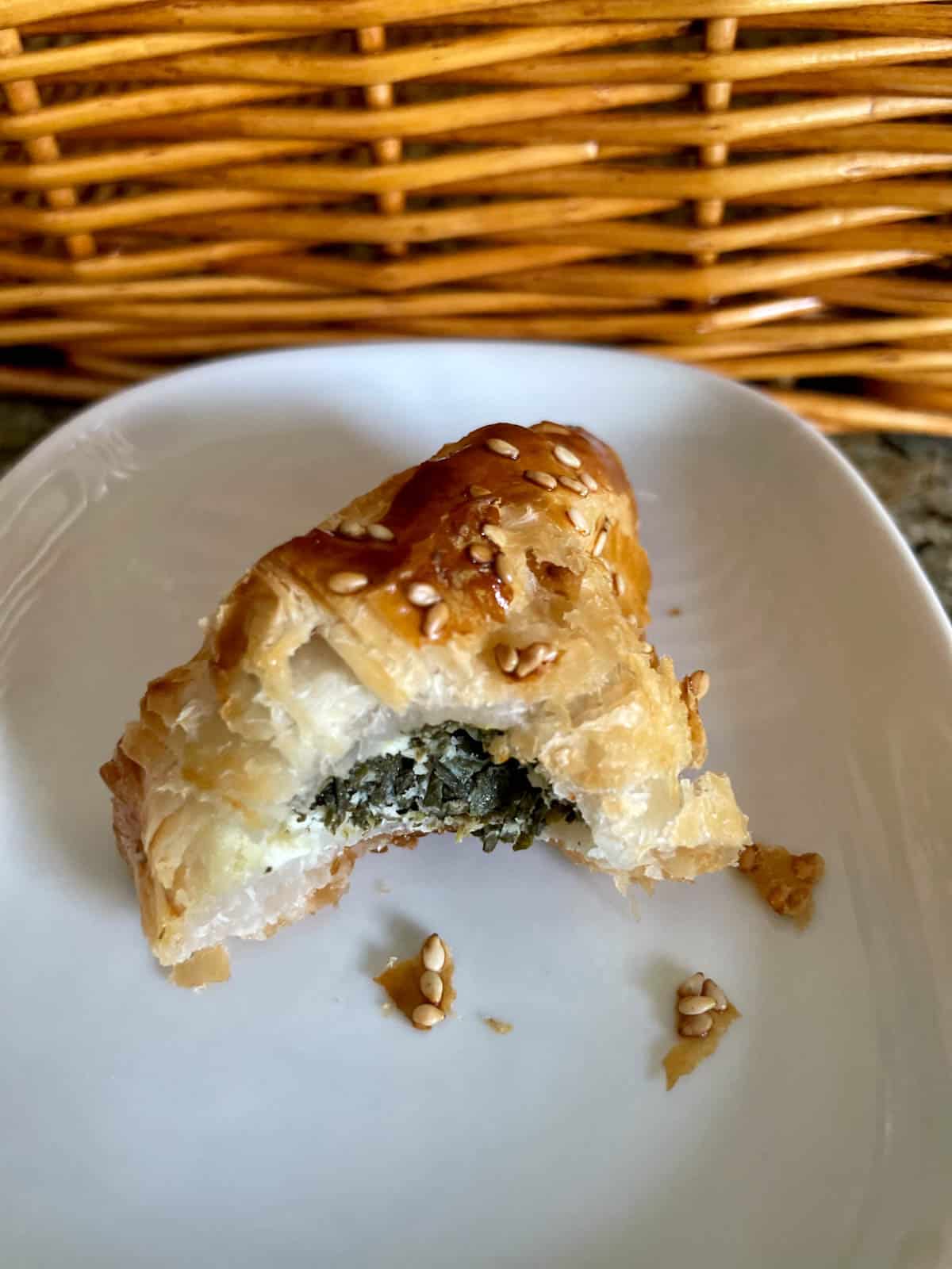 A spinach and feta boureka with a bite taken out showing the filling.