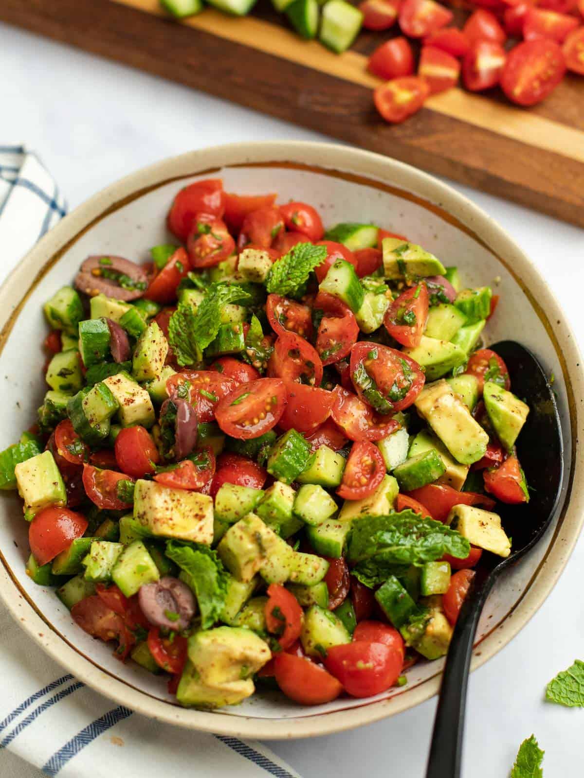 Fresh Jerusalem salad with tomatoes, cucumbers, avocado, and fresh herbs.