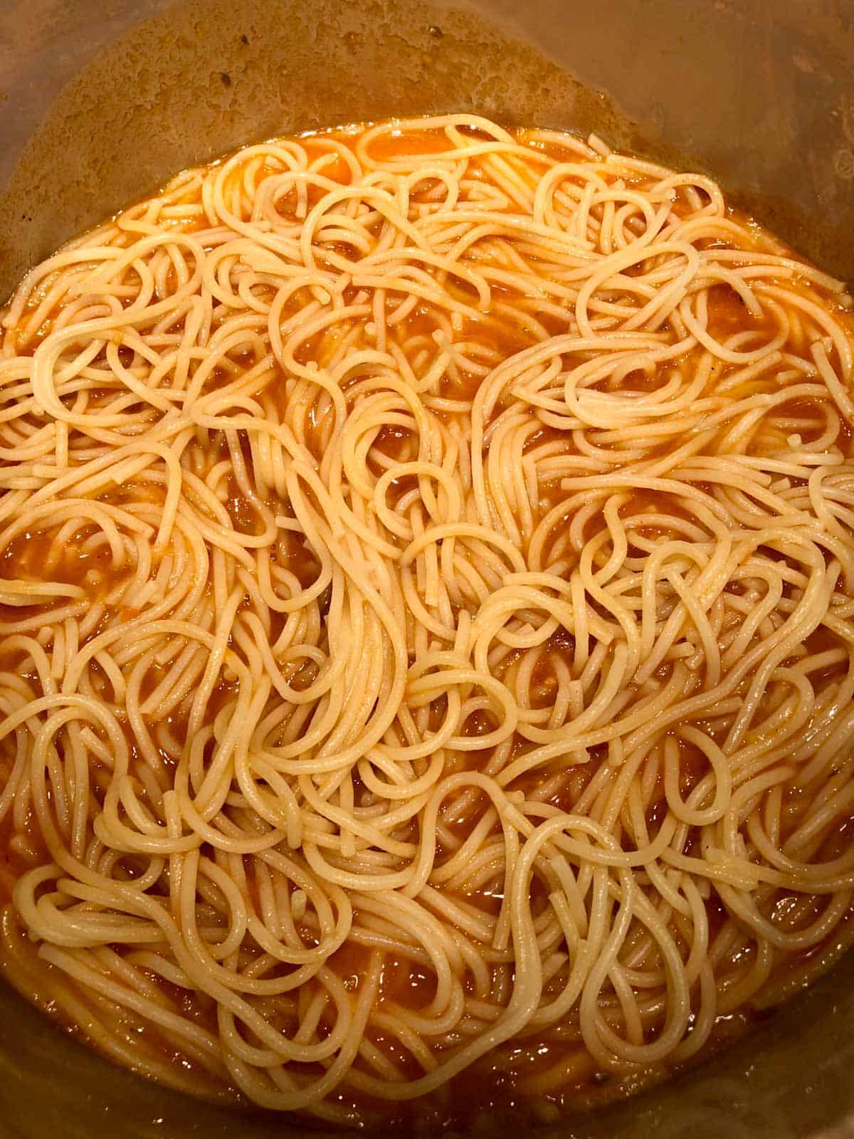 Spaghetti and fresh tomato sauce in a pot.