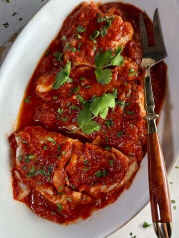 Baccalà cod with tomato sauce in a serving dish.