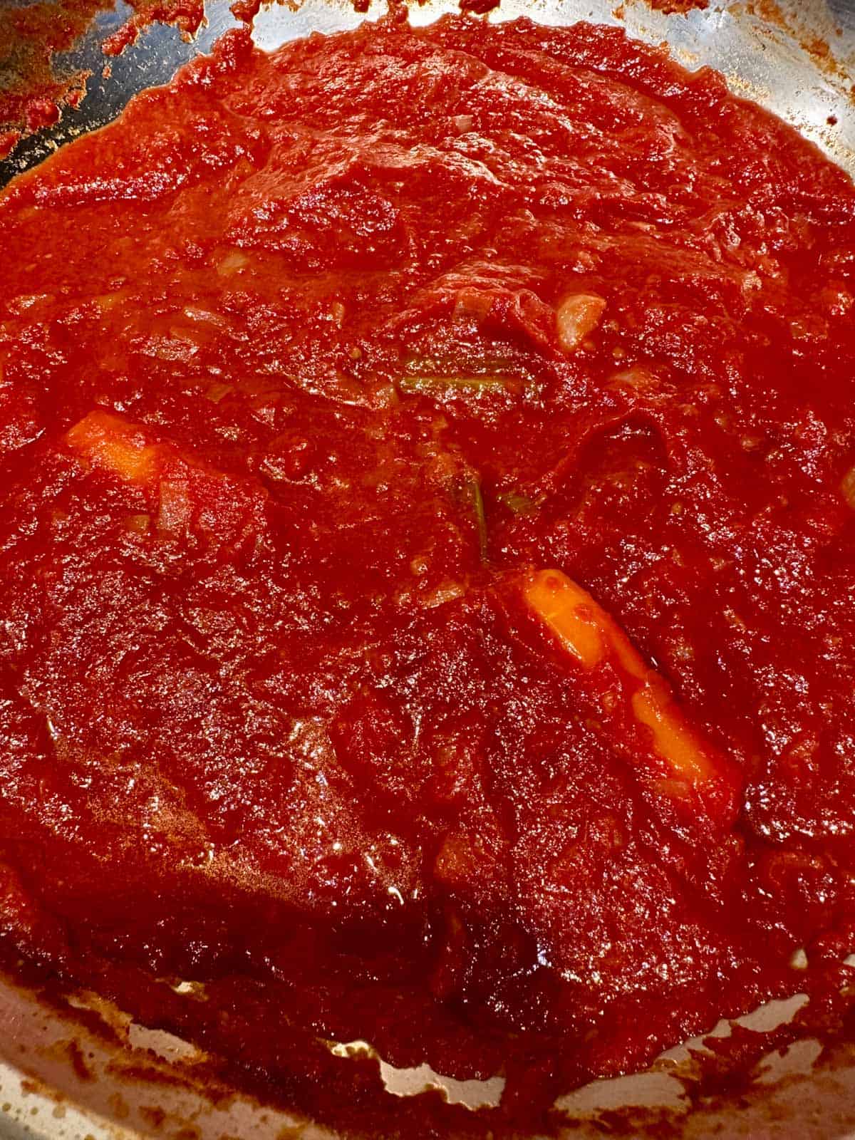 Reduced tomato sauce in a sauté pan.