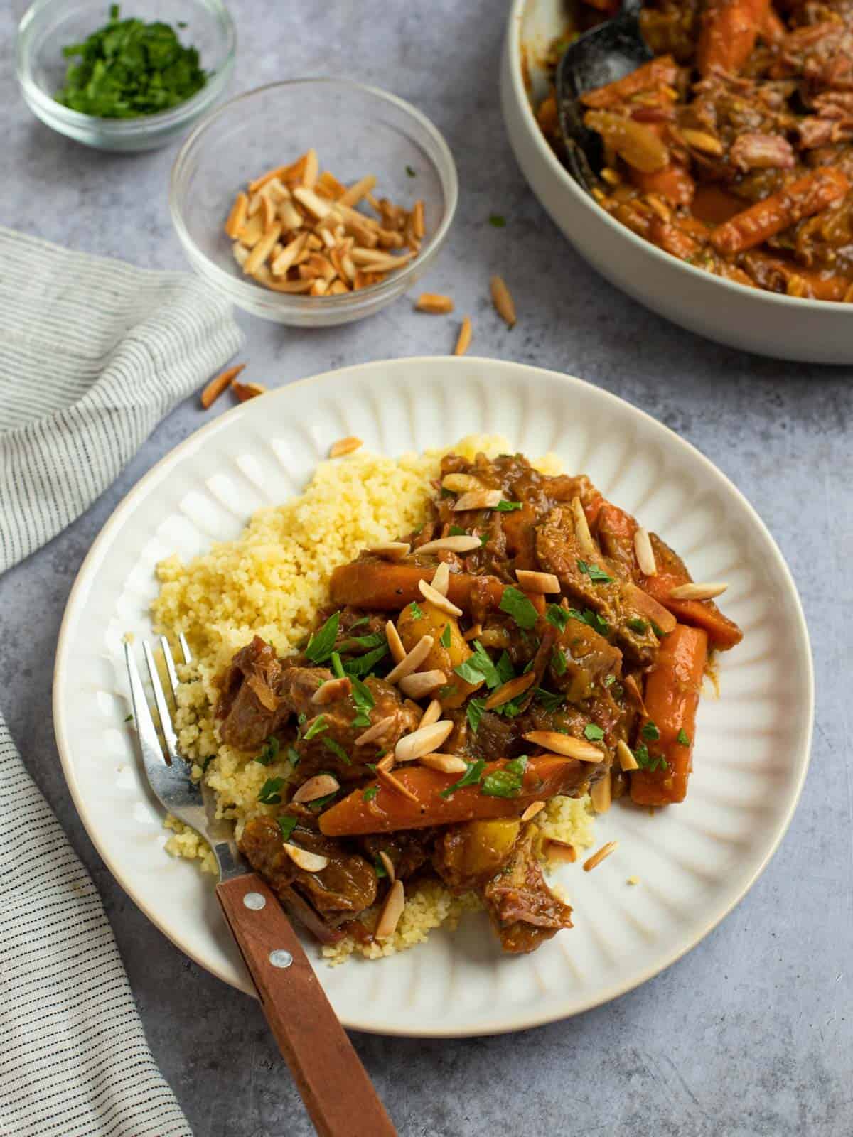 Slow cooker lamb tagine served over couscous on a plate.