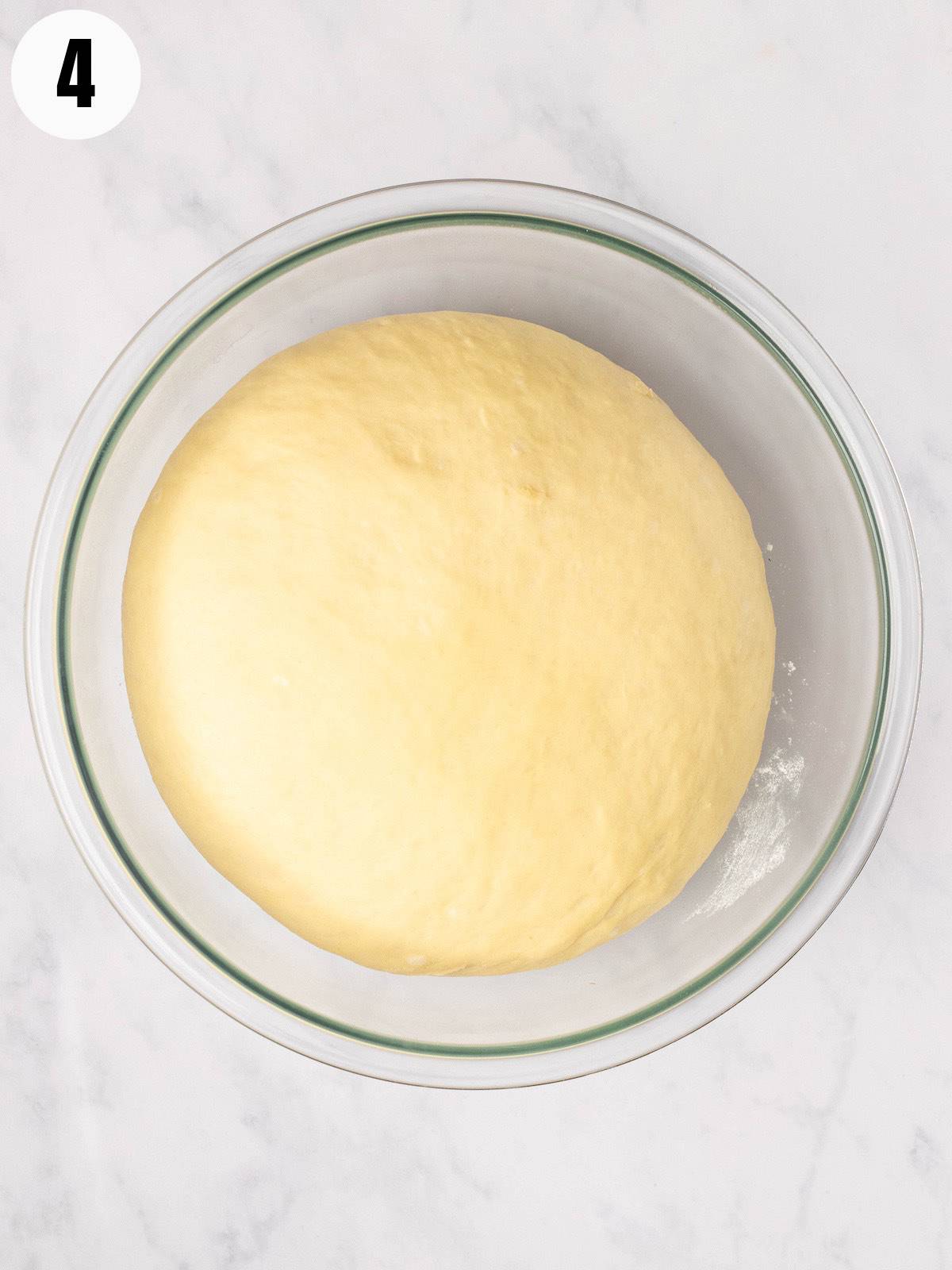 Challah dough rising in a bowl.