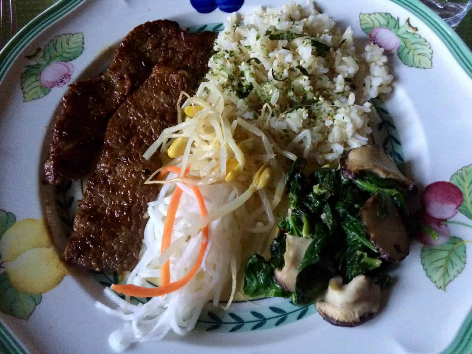 Korean short ribs served with rice and sides.