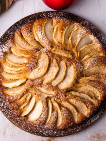 Apple cake with apple slices and powdered sugar.