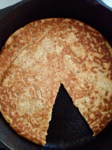 Skillet bread with a wedge taken out.