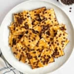 A plate with toffee topped matzo crackers with chocolate chips.