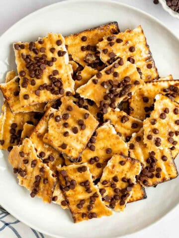 A plate with toffee topped matzo crackers with chocolate chips.