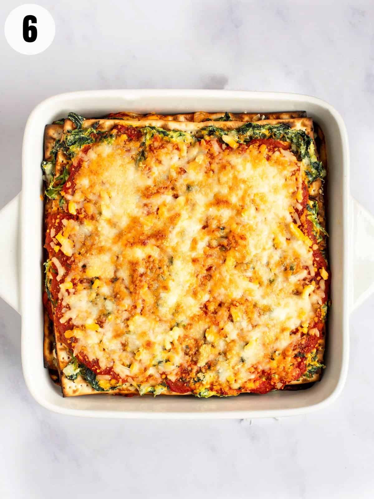 Baked matzo lasagna with melted cheese and spinach.