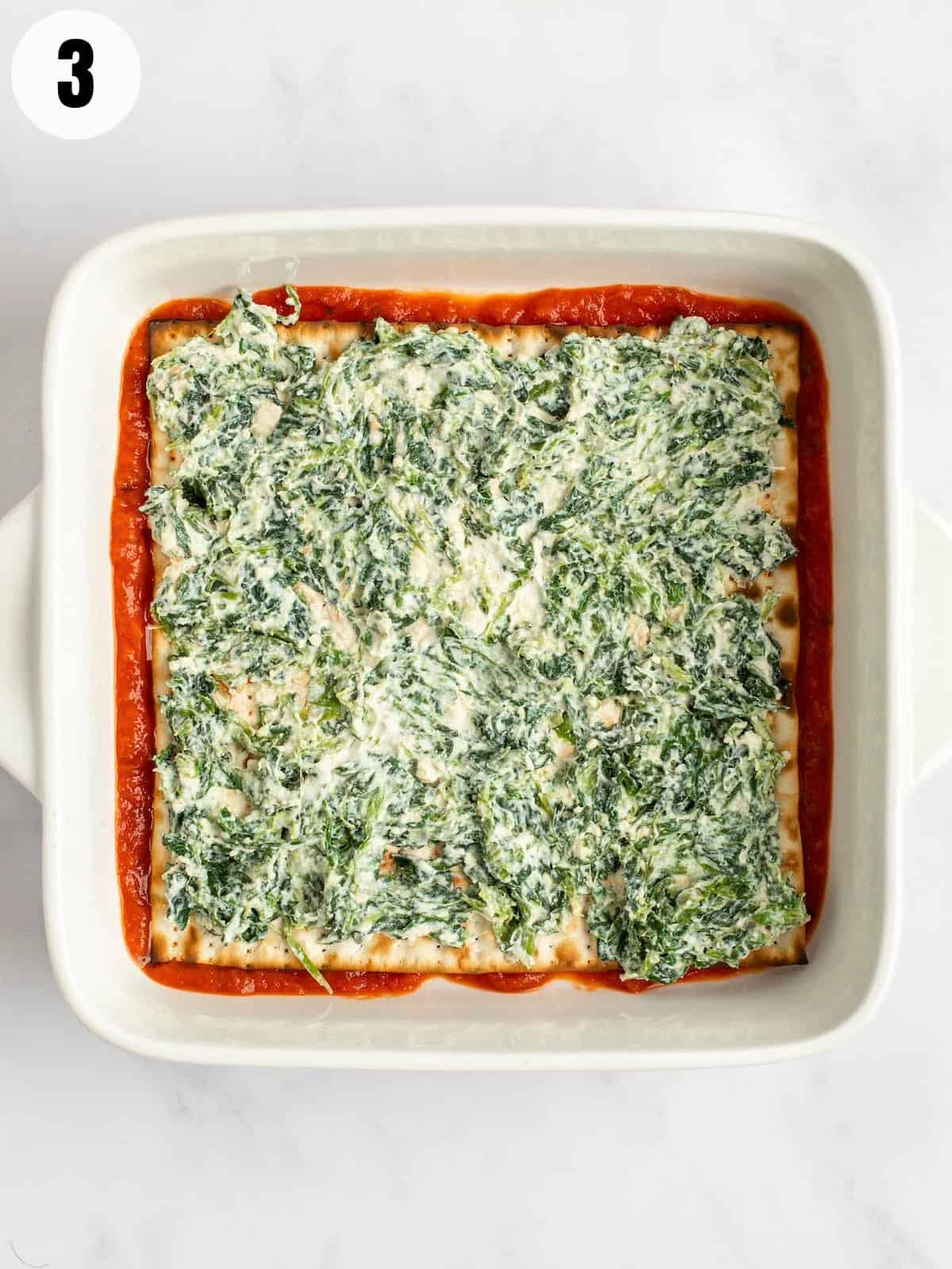 Layering ricotta and spinach on passover lasagna.