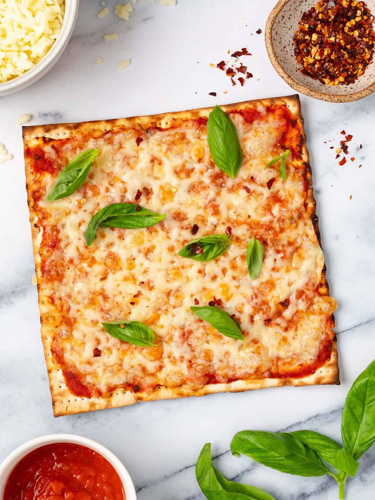 Matzo pizza with fresh basil, mozzarella, and red pepper flakes.