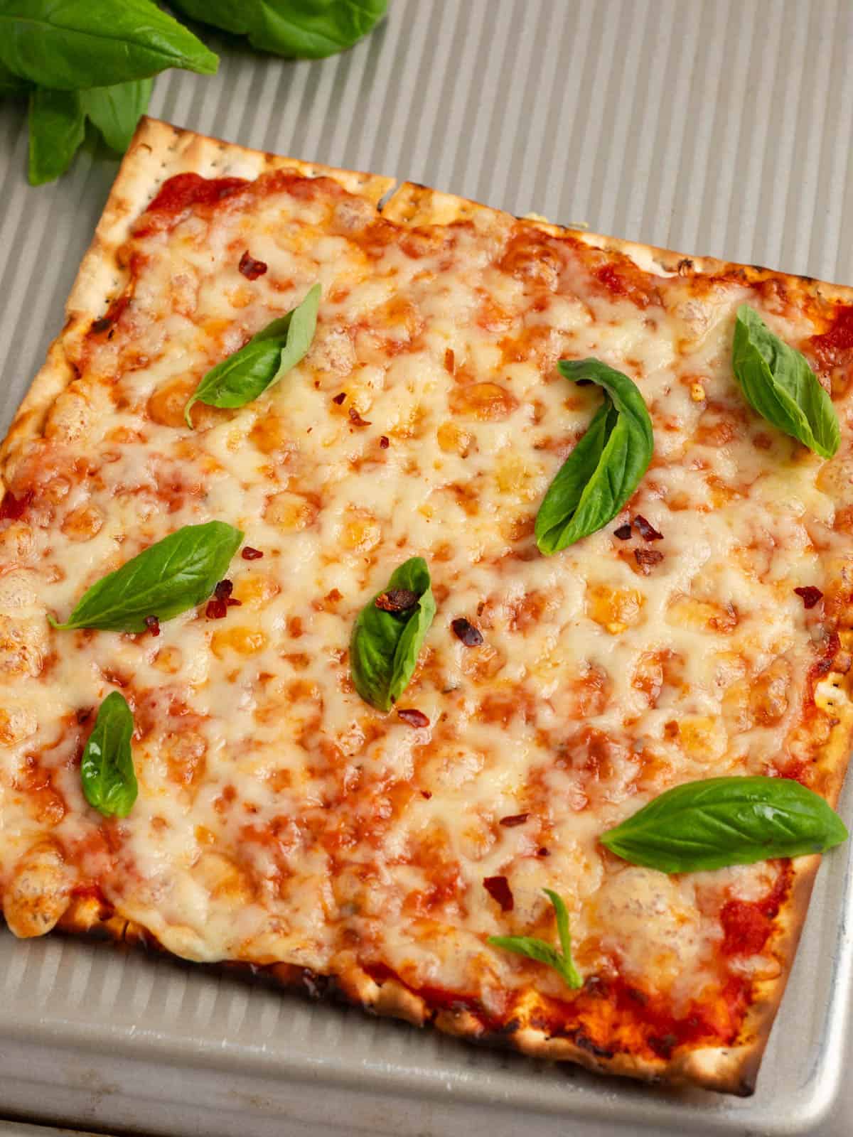 Matzo margherita pizza topped with mozzarella and fresh basil.