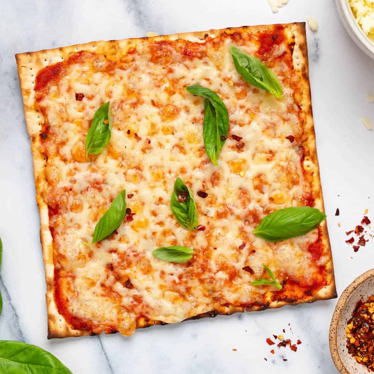 Matzo pizza topped with mozzarella and fresh basil.