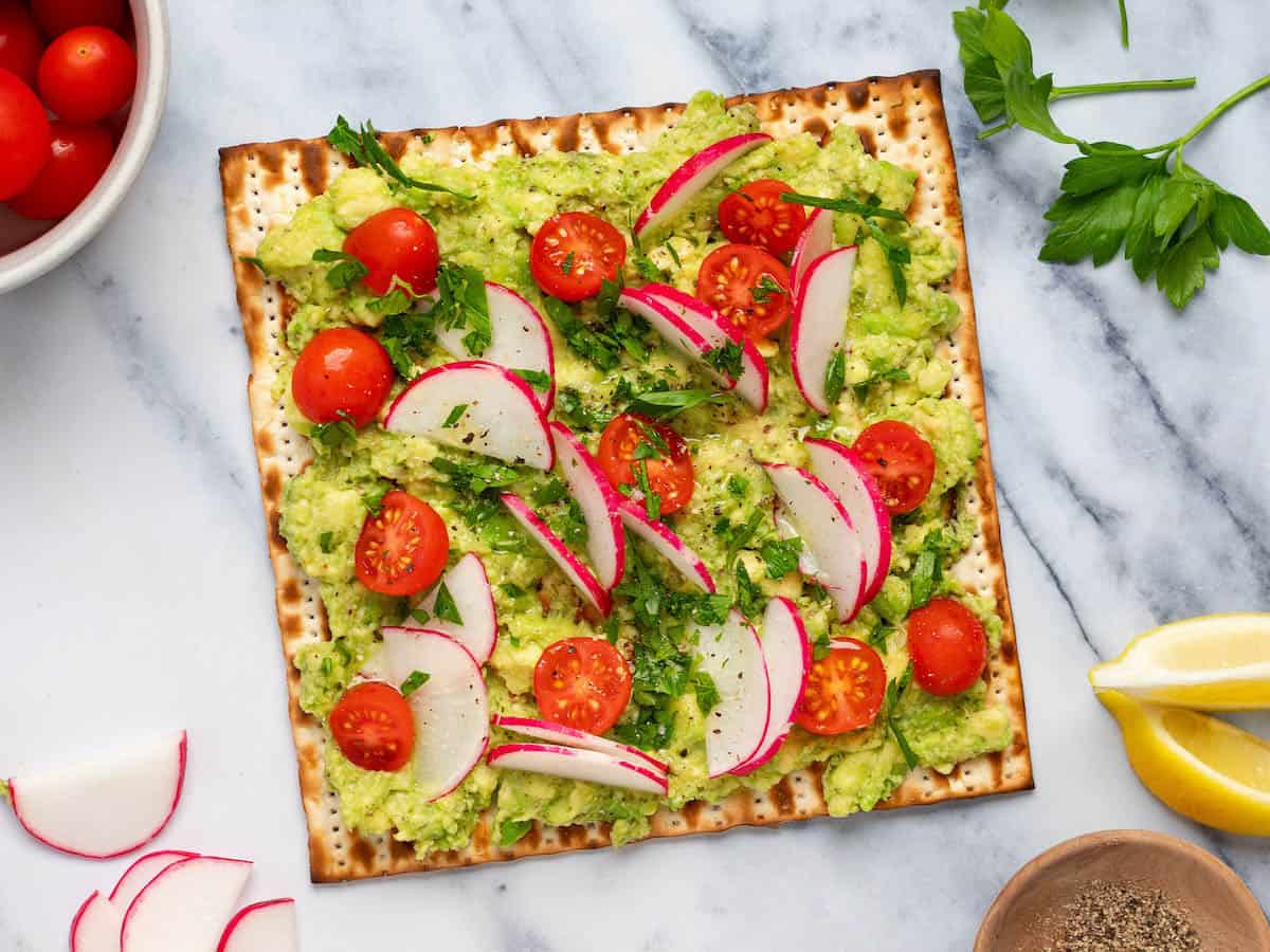 Avocado matzo "toast" with tomatoes and fresh herbs.