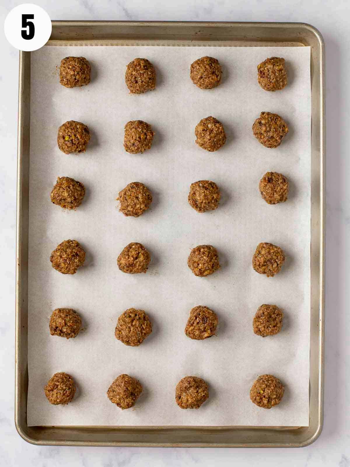 Rolled charoset balls on a baking sheet.