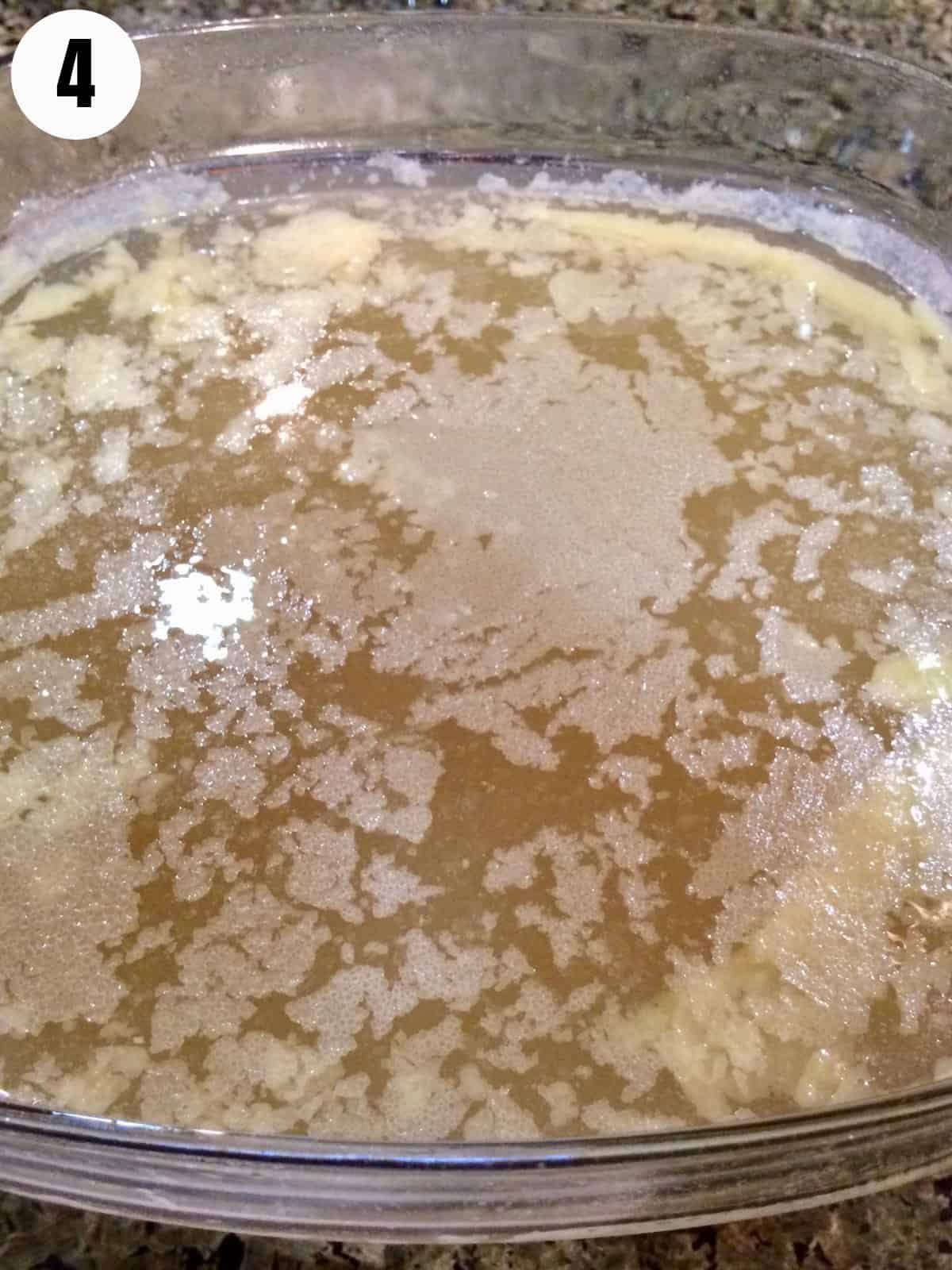 A layer of fat at the top of a bowl of bone broth.