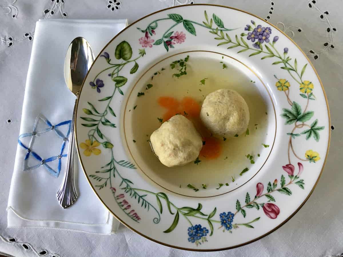 Chicken broth in matzo ball soup in a bowl.