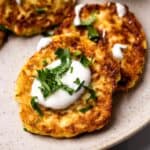 Italian Zucchini Latkes on a plate with dipping sauce.