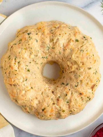 Gefilte fish on a platter with horseradish on the side.