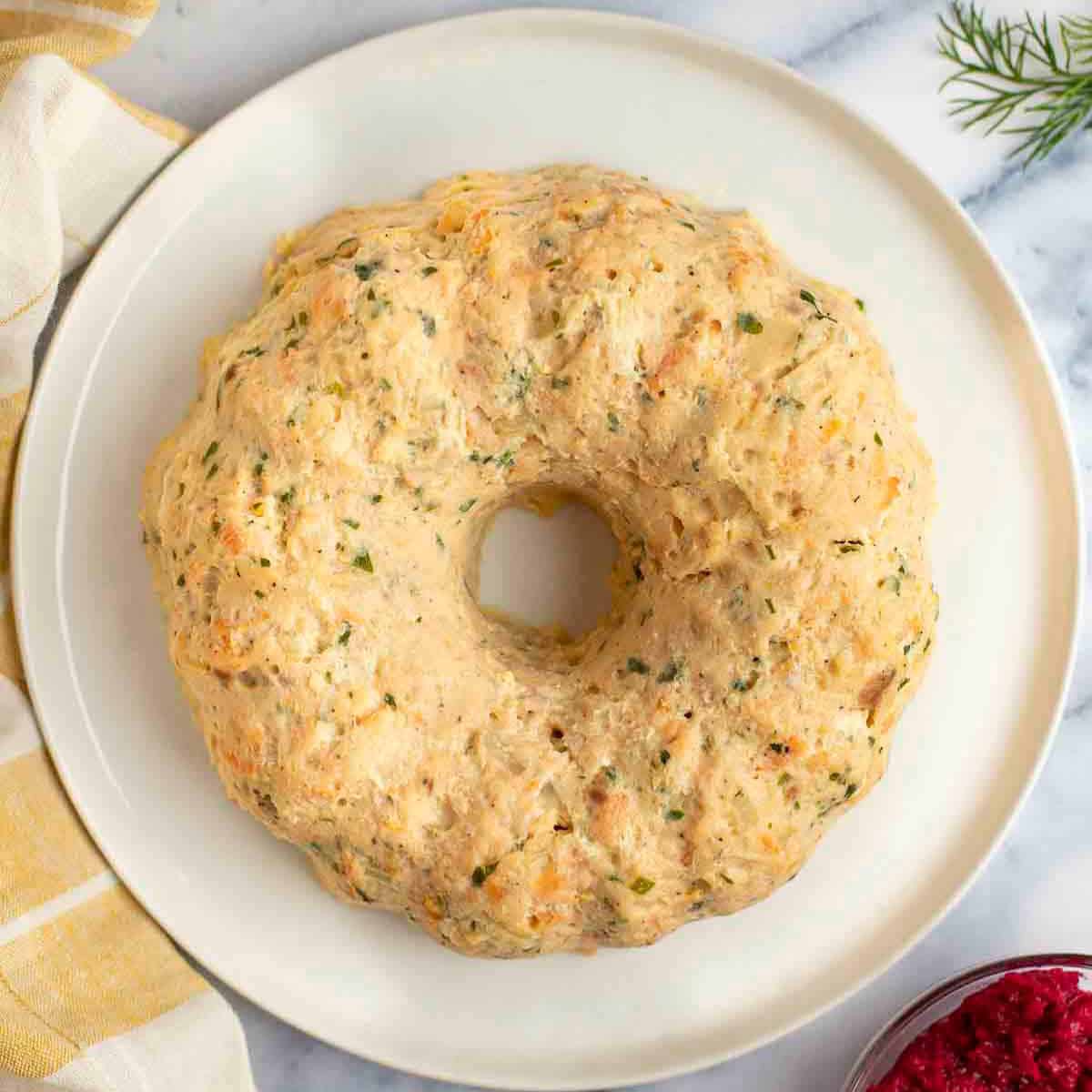 Gefilte fish on a platter with horseradish on the side.