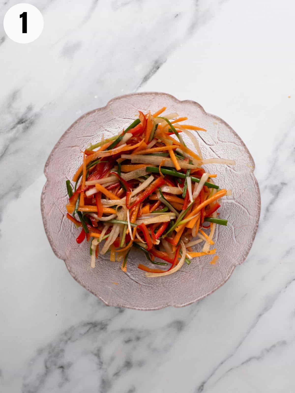 Quick pickling julienned vegetables in a bowl.