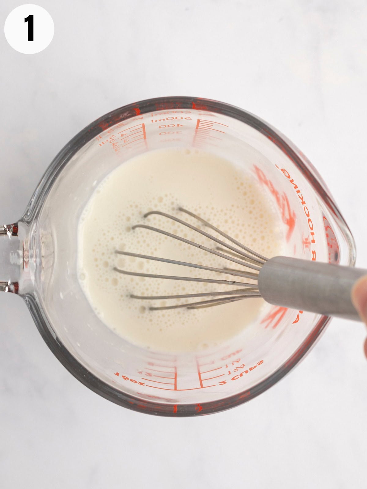 Whisking cornstarch and almond milk in a measuring cup.