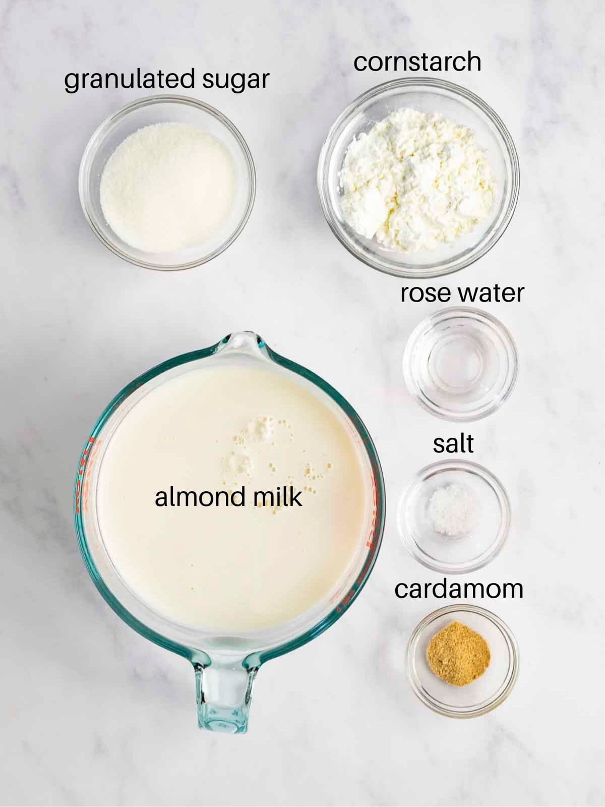 Ingredients for malabi pudding in glass bowls.