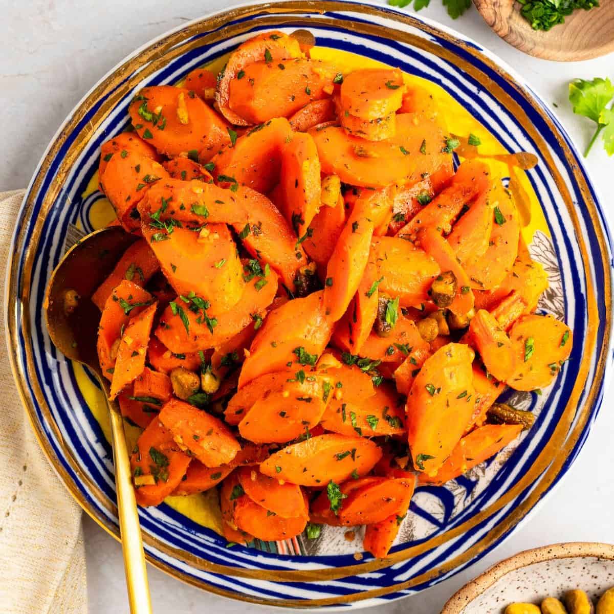 Moroccan carrot salad with parsley garnish in a ceramic serving bowl.