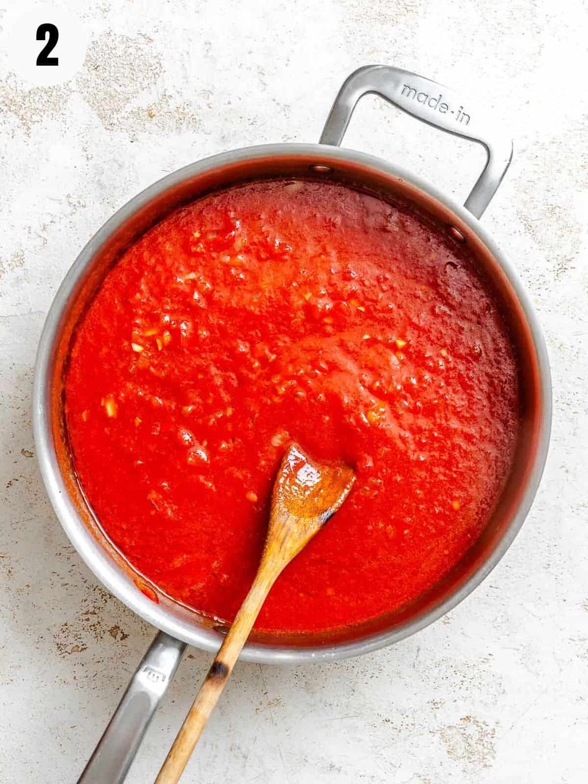 Adding tomatoes and spices to the pot with the veggies.