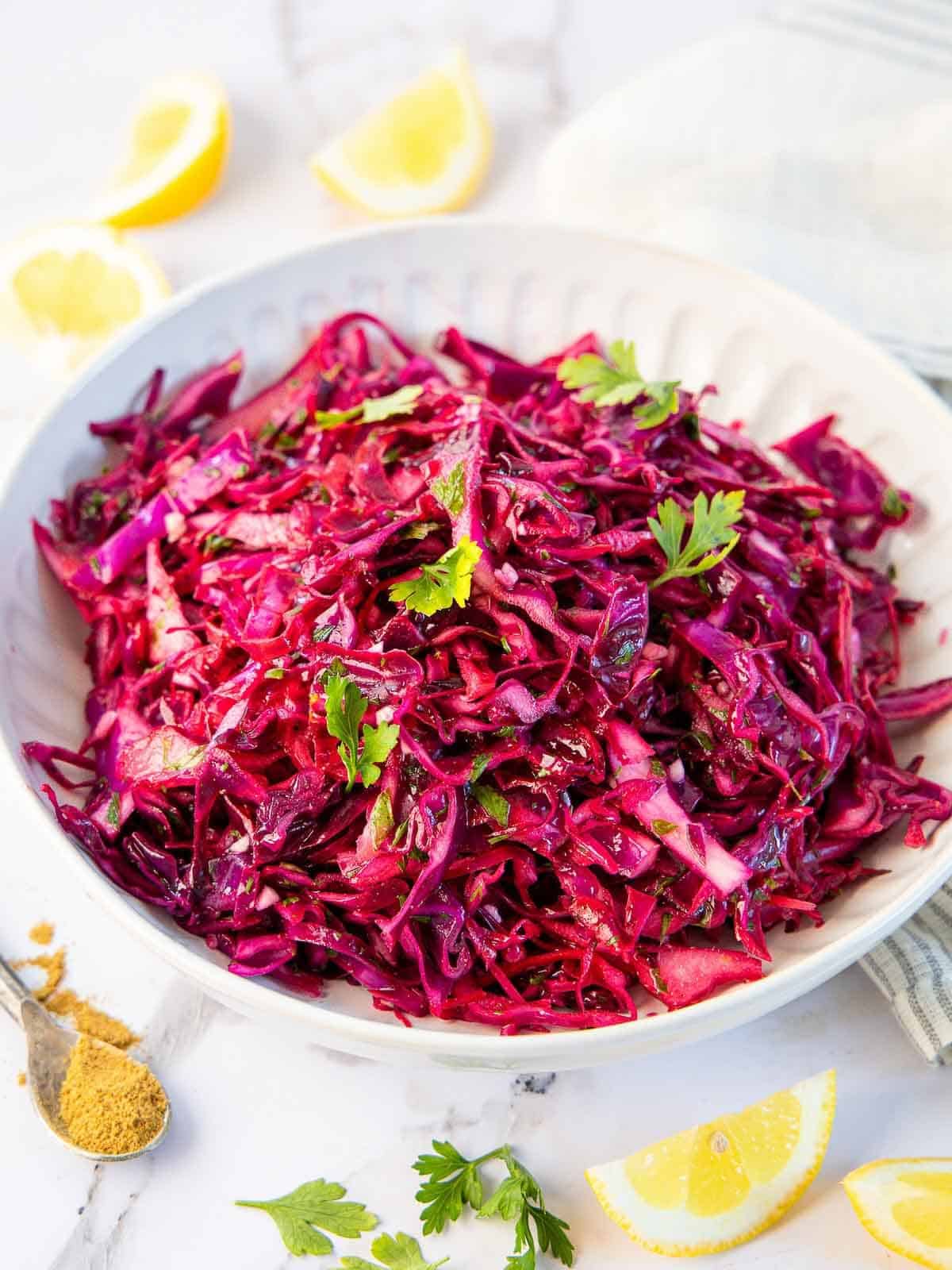 Red cabbage salad in a white bowl.