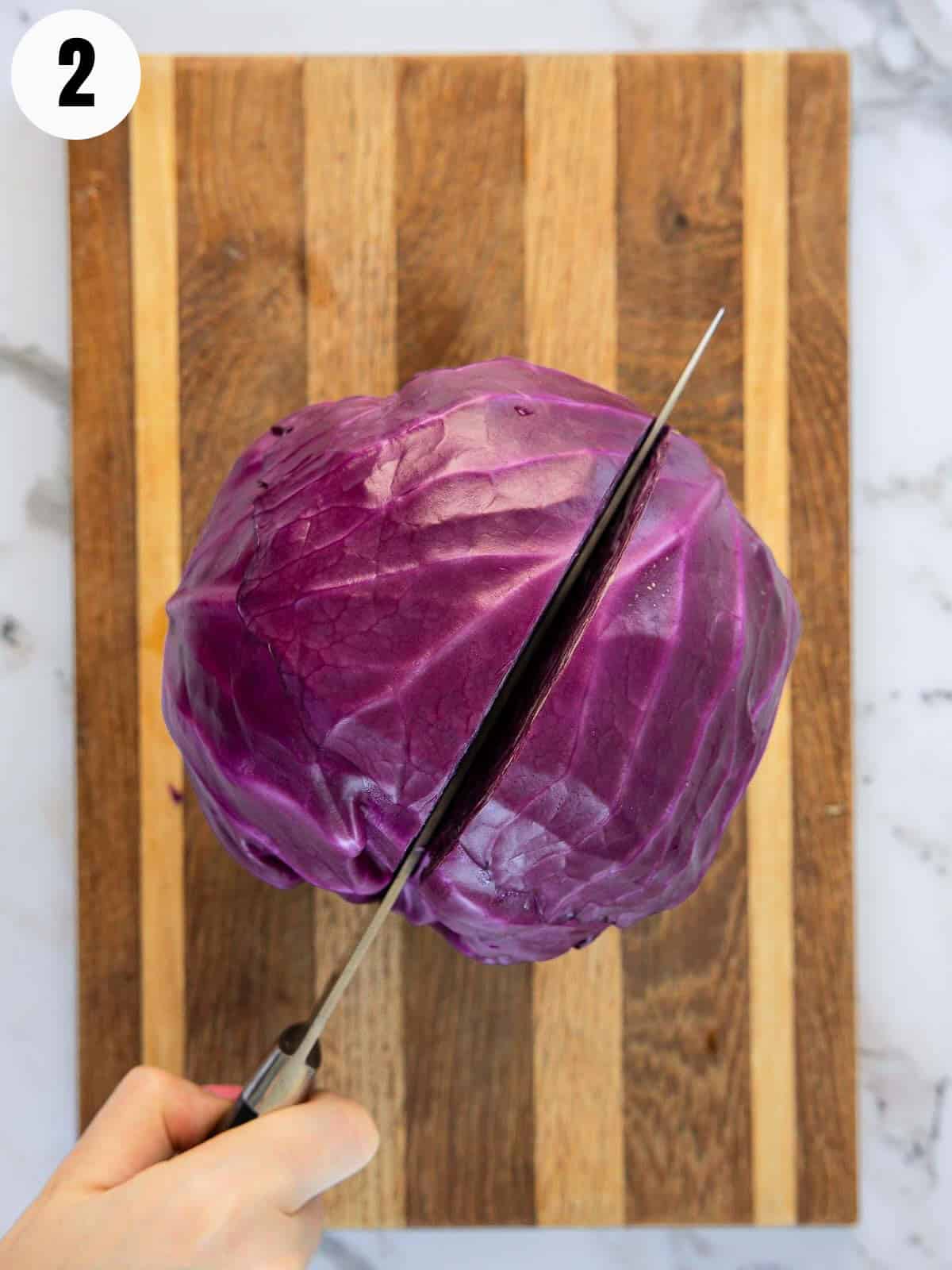 Cutting a red cabbage in half.