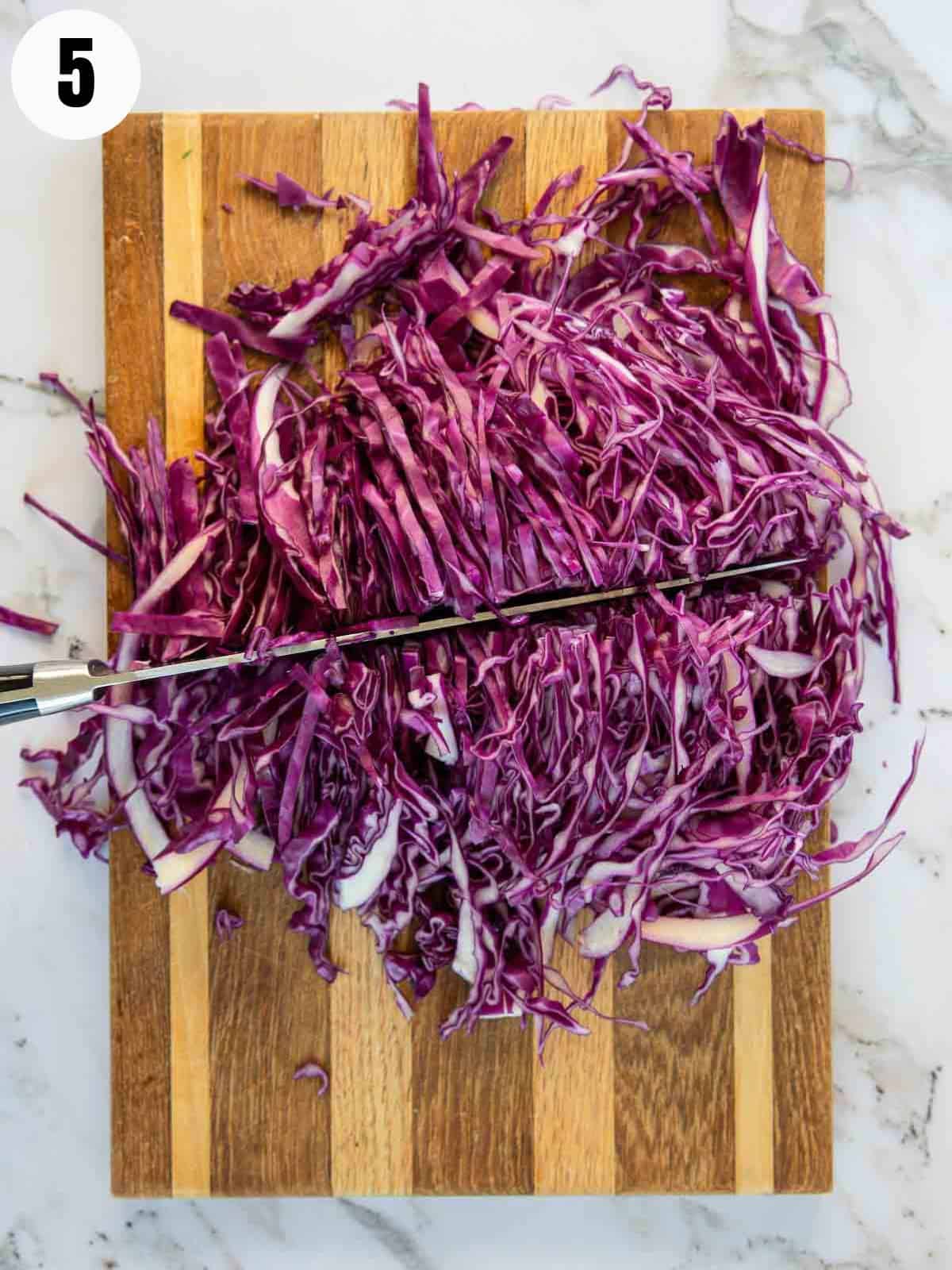 Cutting the sliced cabbage in half.