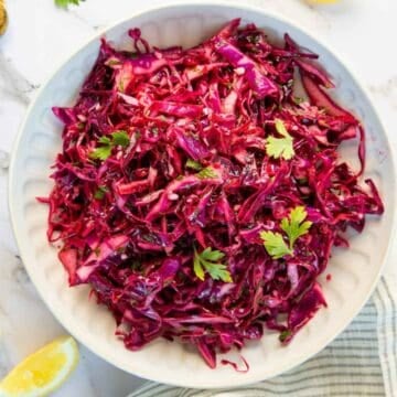 Red cabbage coleslaw in a white bowl.