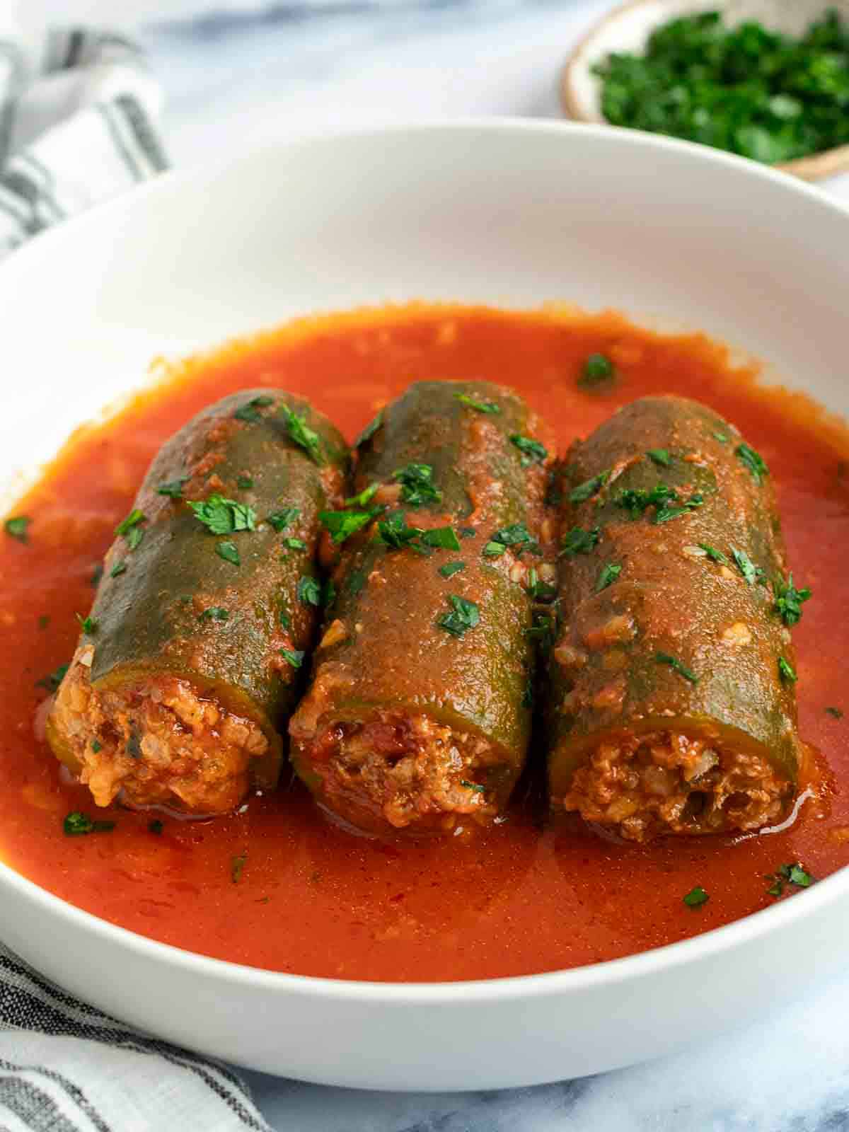 A serving of kousa mahshi, Middle Eastern stuffed zucchinis in tomato sauce,